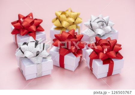 ピンク背景に並ぶカラフルなリボン付きギフトボックス 126503767
