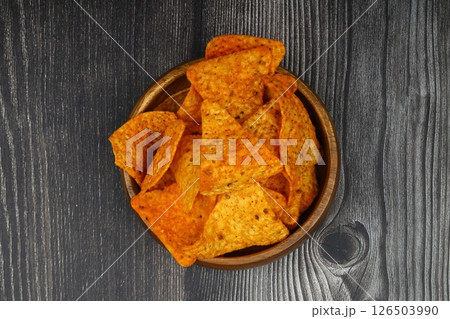 Nachos in a wooden bowl. Tortilla chips on wooden background. Nachos in a wooden bowl. Tortilla chips on wooden background. 126503990