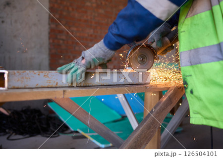 A Worker Skillfully Cutting Material with an Angle Grinder, Sparks Flying Everywhere A Worker Skillfully Cutting Material with an Angle Grinder, Sparks Flying Everywhere 126504101