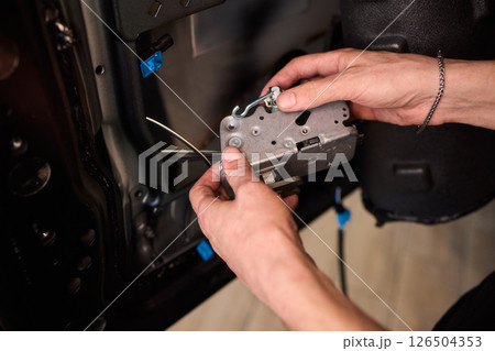 Hands Engaged in the Process of Performing Automotive Interior Repairs Effectively 126504353