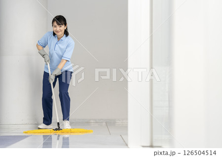 ビル清掃イメージ　フロアのモップかけをする50代の女性清掃スタッフ　カメラ目線 126504514