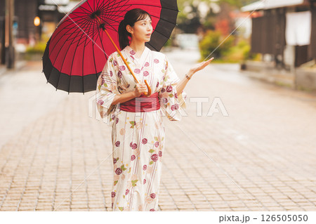 雨の中秋の温泉街を歩く浴衣姿の若い女性【撮影協力・新発田市フィルムコミッション協議会】 雨の中秋の温泉街を歩く浴衣姿の若い女性【撮影協力・新発田市フィルムコミッション協議会】 126505050