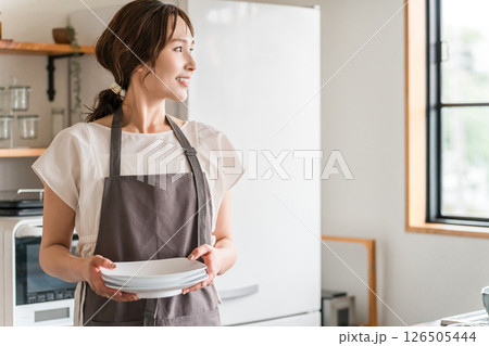 キッチンで家事をするエプロン姿の若いアジア人女性 126505444