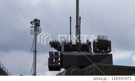 Military personnel skillfully operate advanced weaponry in a training setting, showcasing readiness and precision amid overcast conditions. 126505971