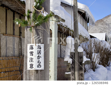 落雪注意と書かれた案内板が柱に設置されている雪国風景 落雪注意と書かれた案内板が柱に設置されている雪国風景 126506946