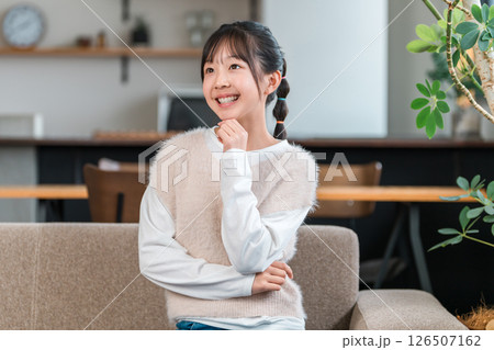 マイホームのソファに座る笑顔の子供,女の子(考える,ひらめく,アイデア,想像) マイホームのソファに座る笑顔の子供,女の子(考える,ひらめく,アイデア,想像) 126507162