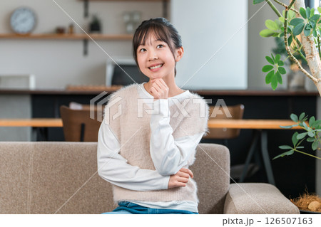 マイホームのソファに座る笑顔の子供,女の子（考える,ひらめく,アイデア,想像） 126507163