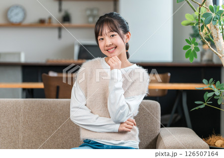 マイホームのソファに座る笑顔の子供,女の子（考える,ひらめく,アイデア,想像） 126507164