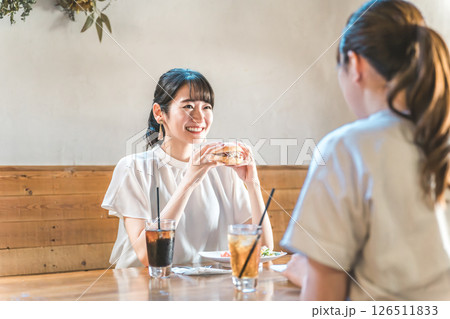 カフェ・レストラン・飲食店でランチをしながらおしゃべりする若いアジア人女性 126511833