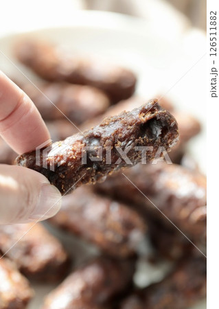 しっかり太めの2度がけ黒糖かりんとうを持つ指 126511882