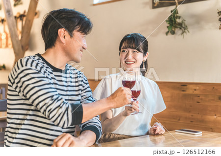 カフェ・レストラン・飲食店でワインで乾杯する男女 カフェ・レストラン・飲食店でワインで乾杯する男女 126512166