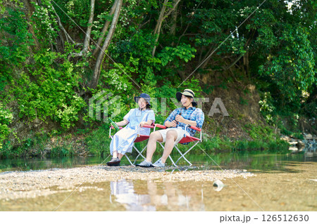 川辺で涼む男女 126512630