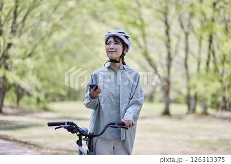 自然の中でサイクリングを楽しむスマートフォンを持った日本人女性 自然の中でサイクリングを楽しむスマートフォンを持った日本人女性 126513375