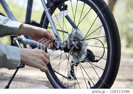 自転車の変速機を工具で調整する女性の手元 自転車の変速機を工具で調整する女性の手元 126513396