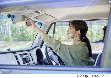 車のバックミラーを調整する日本人の女性ドライバー 126513402