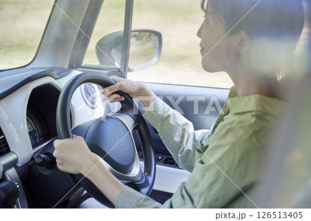 車のハンドルを握る日本人女性の手元 126513405