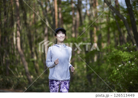 自然豊かな森の中でランニングを行う日本人女性 126513449