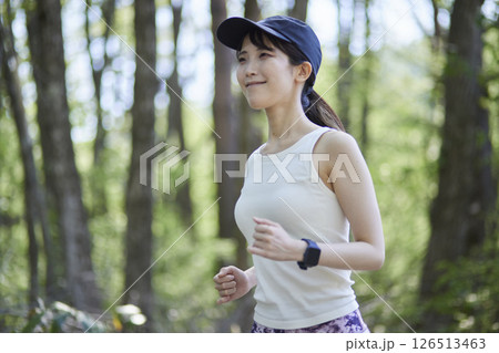 自然豊かな森の中でランニングを行う日本人女性 126513463