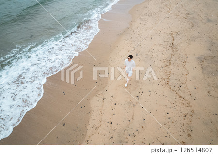 海岸を歩くワーケーション中の男性の空撮 126514807