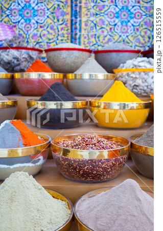 Traditional spices market. Pots and wooden tubs stand in row with colorful tea, spices, fruits, roots, flowers. Street bazaar. Dubai, UAE. Vertical photo 126515559