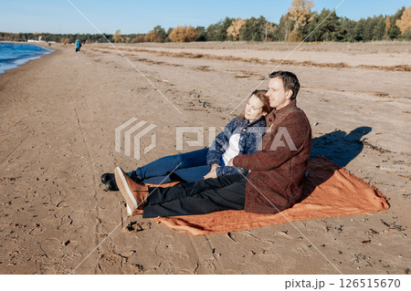 Portrait loving couple walks on beach along sea on sunny autumn day. Weekend and lifestyle concept. High quality photo Portrait loving couple walks on beach along sea on sunny autumn day. Weekend and lifestyle concept. High quality photo 126515670