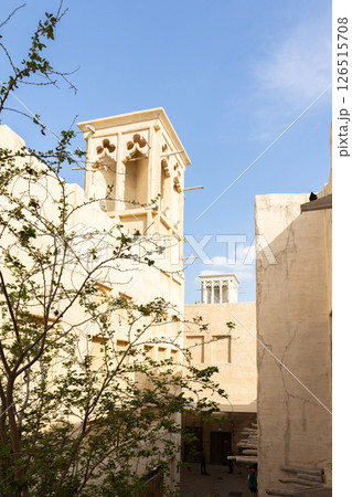Old town in Al Seef Cultural Historical District on shores of Dubai Creek. Tourist place with old streets, houses and shops, Dubai, UAE. Vertical photo 126515708