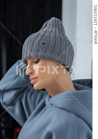 Portrait beautiful woman in grey hat. Pretty girl in warm clothes on black background. Studio photography. Vertical photo. High quality photo 126515901