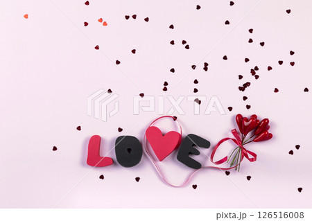 Valentine's day romantic party concept. Gift word LOVE and bouquet of sweet hearts decorations on pink background. Top view, flat lay, copy space 126516008