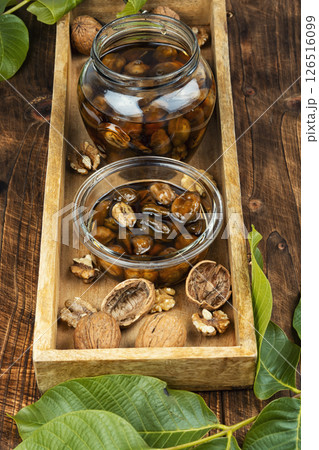Young Green walnut jam on wooden surface. Young Green walnut jam on wooden surface. 126516099