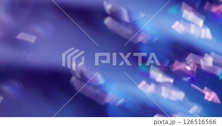 Defocused shine particles. Crystal glow. Gleam white sparks lens flare twirling on blue purple color bokeh light background. 126516566