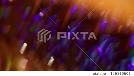 Crystal radiance. Blur sparkle. Multicolored particles lens flare turning on purple yellow blue orange bokeh light background. 126516601