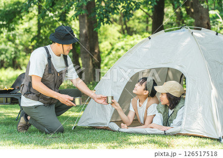 キャンプで熱中症対策のためテントの中で水分補給する家族（コーヒー・お茶） 126517518