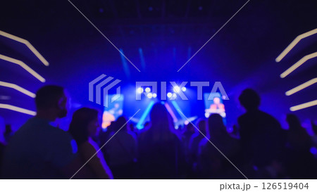 Crowd enjoying live music concert with blue stage lights illuminating audience 126519404