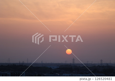 夕焼けに染まる空と沈む太陽の美しい風景（電線のある郊外） 126520481