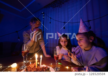 Celebration of joy and togetherness filled with laughter as friends enjoy a cozy gathering under soft lighting on a special evening Celebration of joy and togetherness filled with laughter as friends enjoy a cozy gathering under soft lighting on a special evening 126520504
