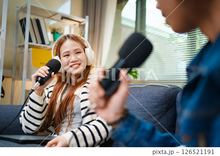 Podcast conversation between young man and woman with headphones and microphones Podcast conversation between young man and woman with headphones and microphones 126521191