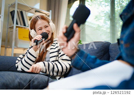 Podcast conversation between young man and woman with headphones and microphones Podcast conversation between young man and woman with headphones and microphones 126521192