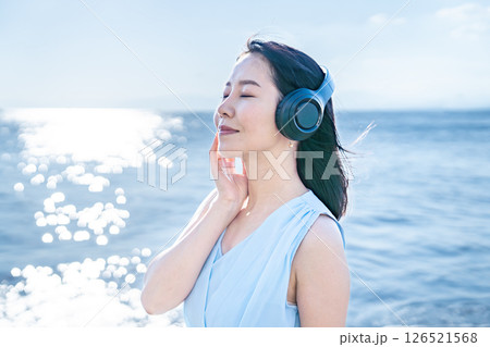 海で音楽を聴くノースリーブの女性 126521568