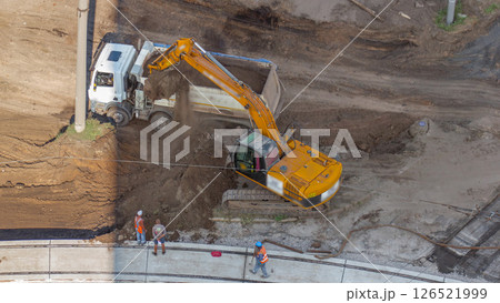Industrial truck loader excavator moving ground and loading into a dumper truck timelapse Industrial truck loader excavator moving ground and loading into a dumper truck timelapse 126521999