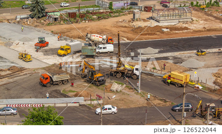 Aerial view of large road construction site with several industrial machines timelapse. Aerial view of large road construction site with several industrial machines timelapse. 126522044