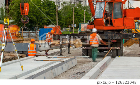Installing concrete plates by crane at road construction site timelapse. 126522048