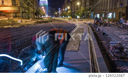 Tram rails at the stage of their installation and integration into concrete plates on the road night timelapse 126522087