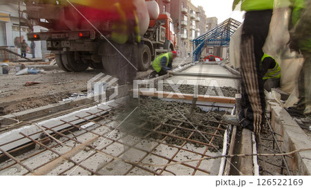 Pouring ready-mixed concrete after placing steel reinforcement to make the road by concrete mixer timelapse hyperlapse. 126522169