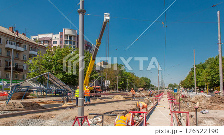 Yellow construction telescopic mobile crane moving tram rails timelapse. 126522190