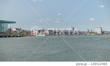 Panoramic view of Amsterdam Central Station with its curved roof and the Amstel River timelapse. Amsterdam, Netherlands Panoramic view of Amsterdam Central Station with its curved roof and the Amstel River timelapse. Amsterdam, Netherlands 126522464