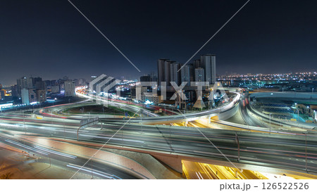 Traffic on a big road junction in Ajman aerial view from rooftop at night timelapse. 126522526