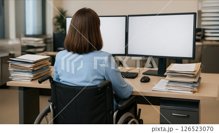 Businesswoman in wheelchair working with dual monitors in office Businesswoman in wheelchair working with dual monitors in office 126523070