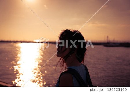 港の夕日を眺める女性 港の夕日を眺める女性 126523160