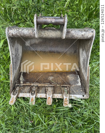 Rusty metal bucket is sitting on the grass 126524011