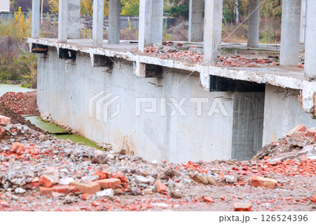 Reveals large concrete structure undergoing construction demolition surrounding debris includes bricks rubble, creating desolate atmosphere. 126524396